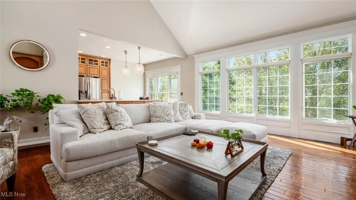 Living area featuring dark wood finished floors, high vaulted ceiling, and recessed lighting