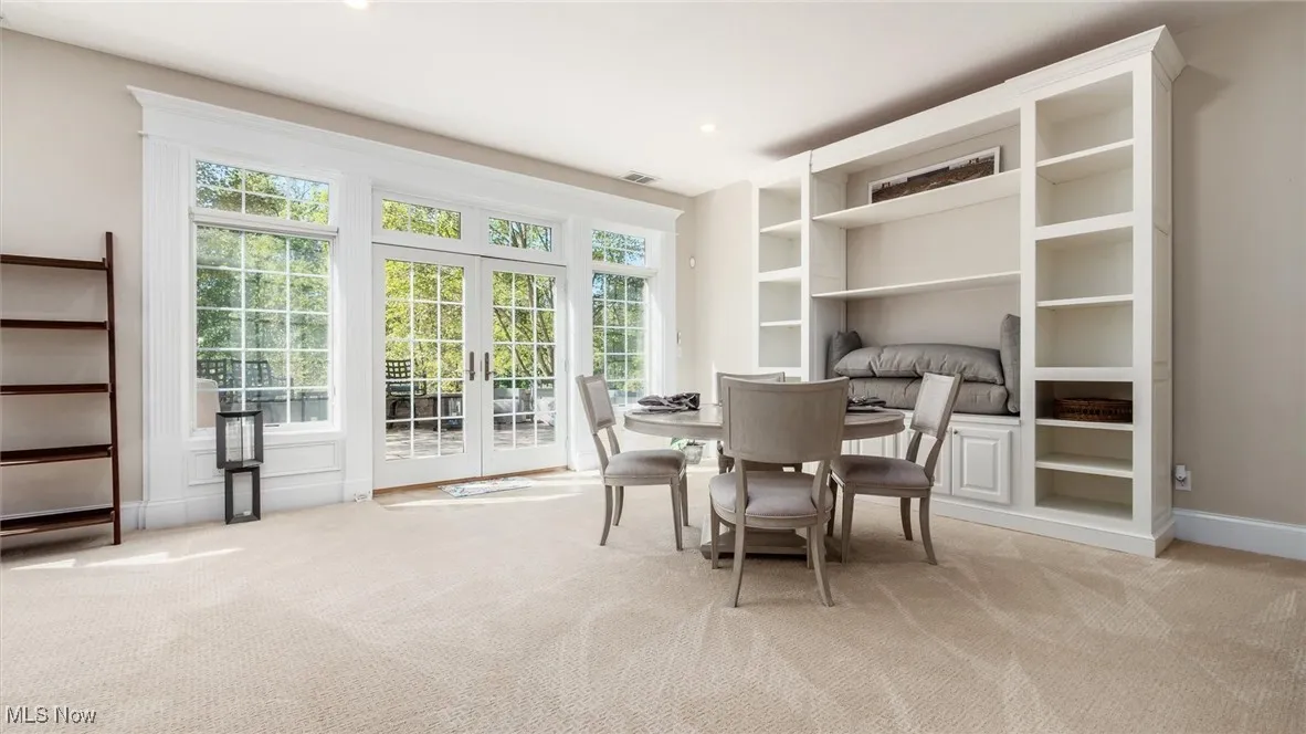 Dining space featuring french doors, light colored carpet, built in features, and recessed lighting