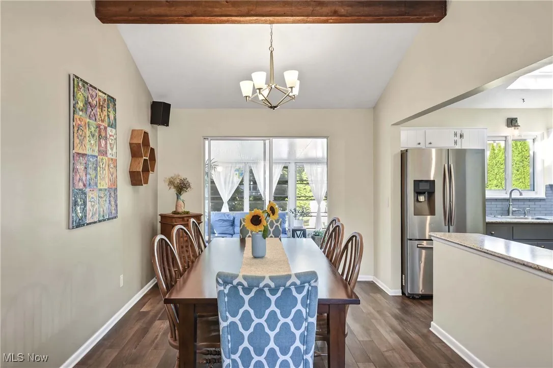 Dining area with dark wood-type flooring and a chandelier
