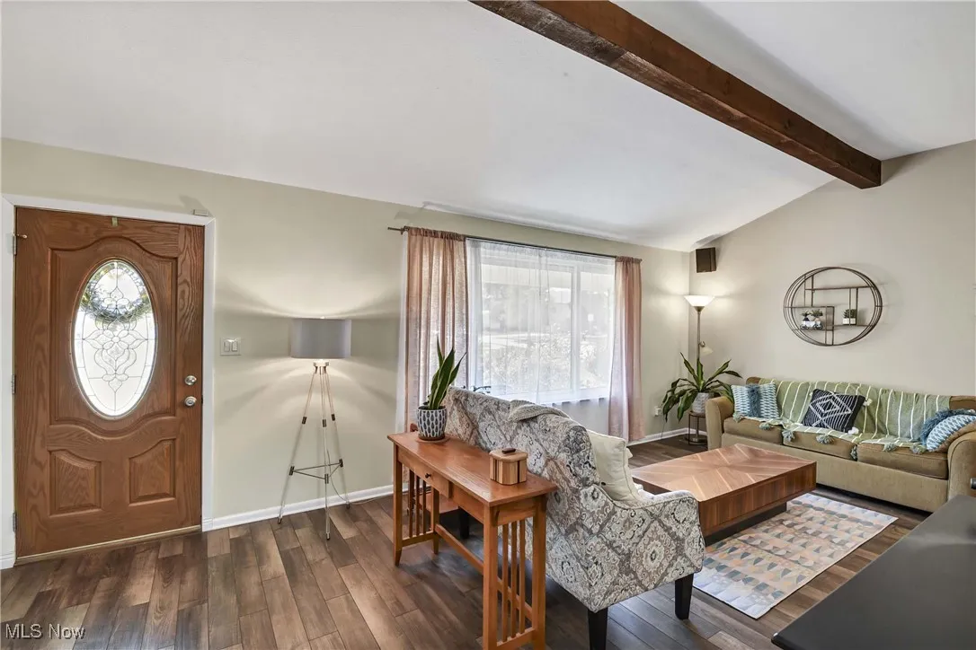 Living room featuring dark wood-style floors and baseboards