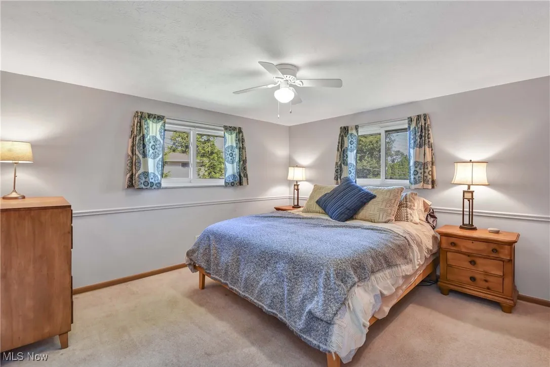 Carpeted bedroom featuring baseboards and ceiling fan