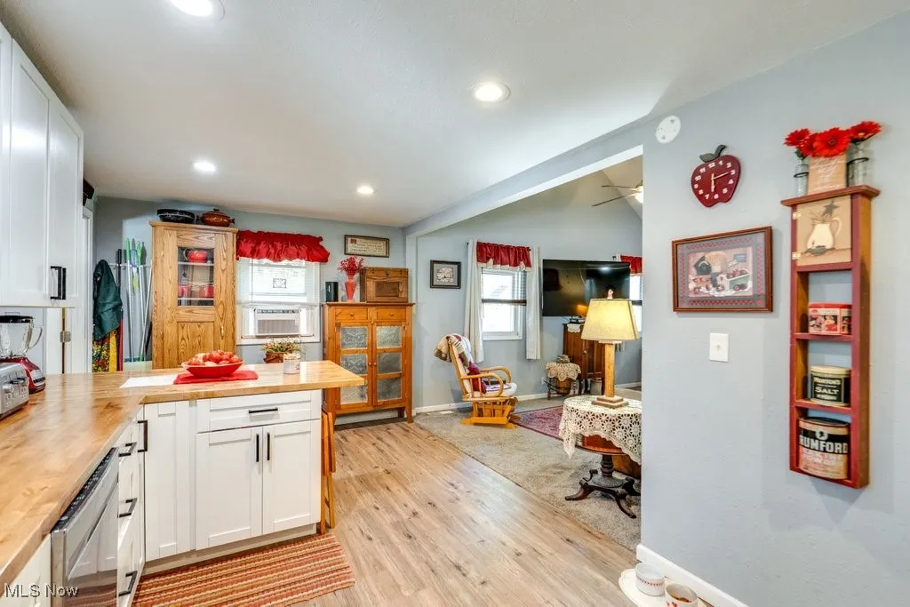Kitchen featuring white cabinets, light wood finished floors, recessed lighting, and a peninsula