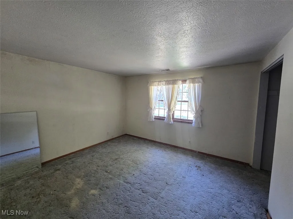 Bedroom with a textured ceiling and carpet flooring