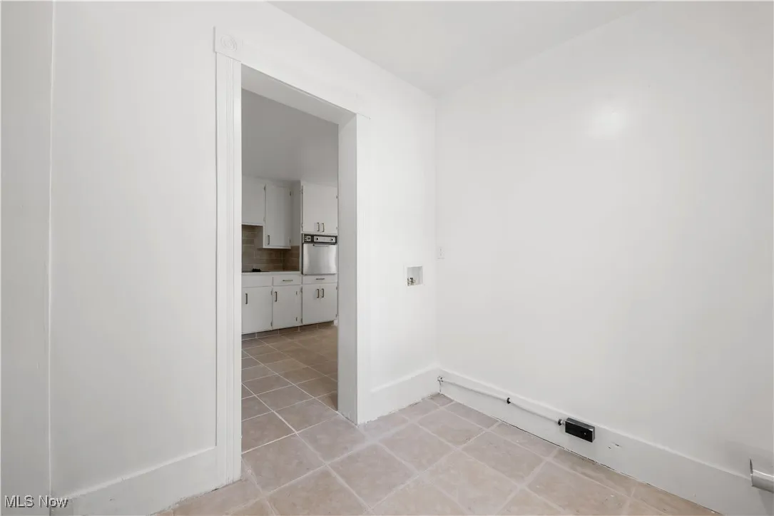 Laundry room with light tile patterned floors and hookup for a washing machine