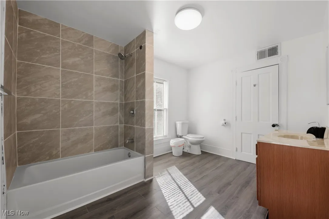 Upstairs Bathroom with shower / bathtub combination, vanity, and dark wood-type flooring