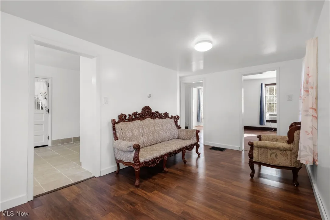 Living area featuring dark wood-style floors and baseboards