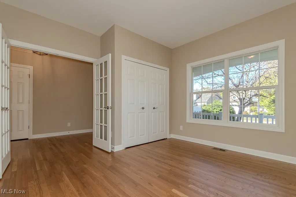 Unfurnished bedroom featuring light wood-type flooring, a closet, and french doors