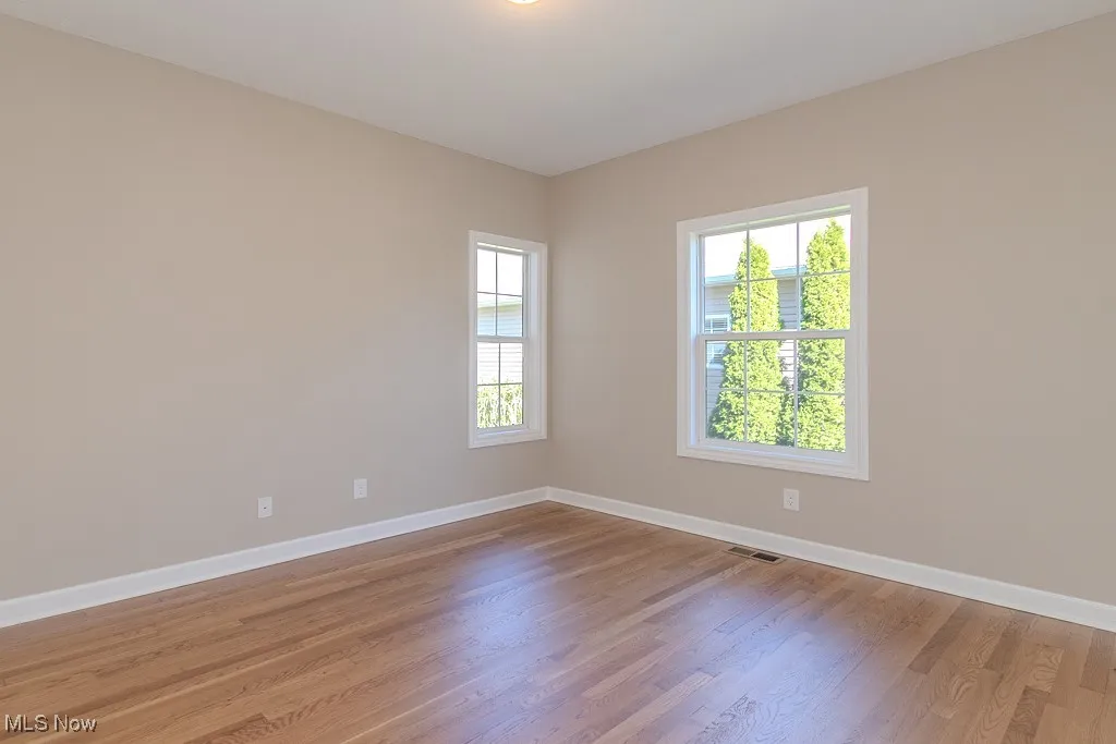 Spare room featuring baseboards and light wood finished floors
