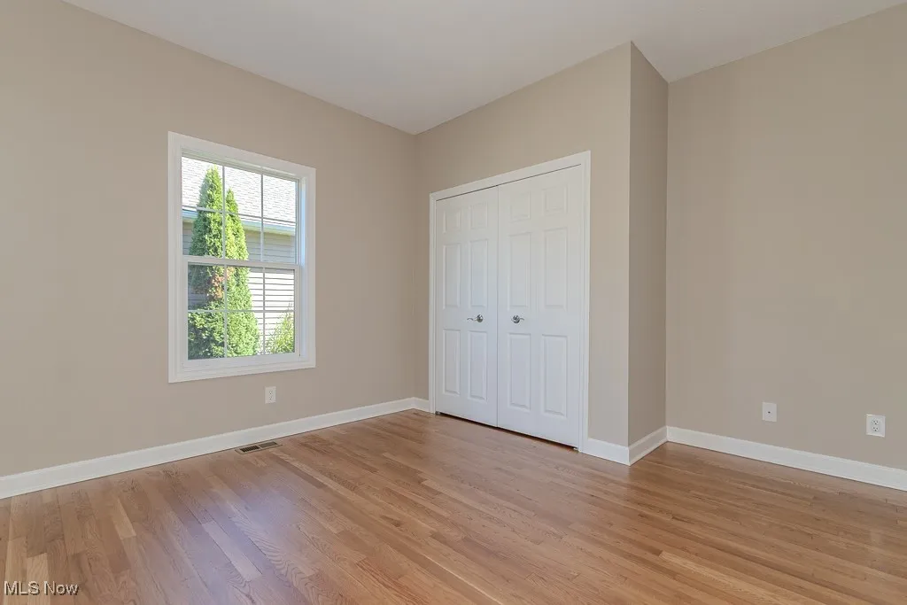 Unfurnished bedroom featuring light wood-style floors and a closet