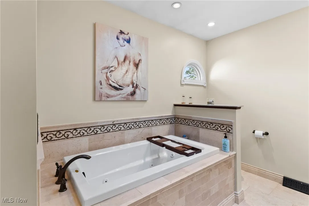 Bathroom with a whirlpool tub, recessed lighting, and tile patterned floors