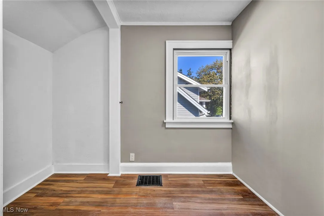 Additional living space with dark wood finished floors and baseboards