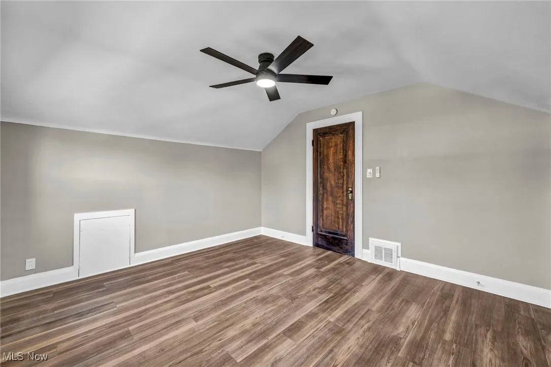 Bonus room with lofted ceiling, dark wood-type flooring, and a ceiling fan