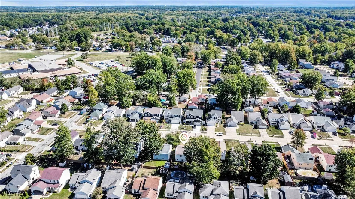 Aerial view of property and surrounding area featuring nearby suburban area