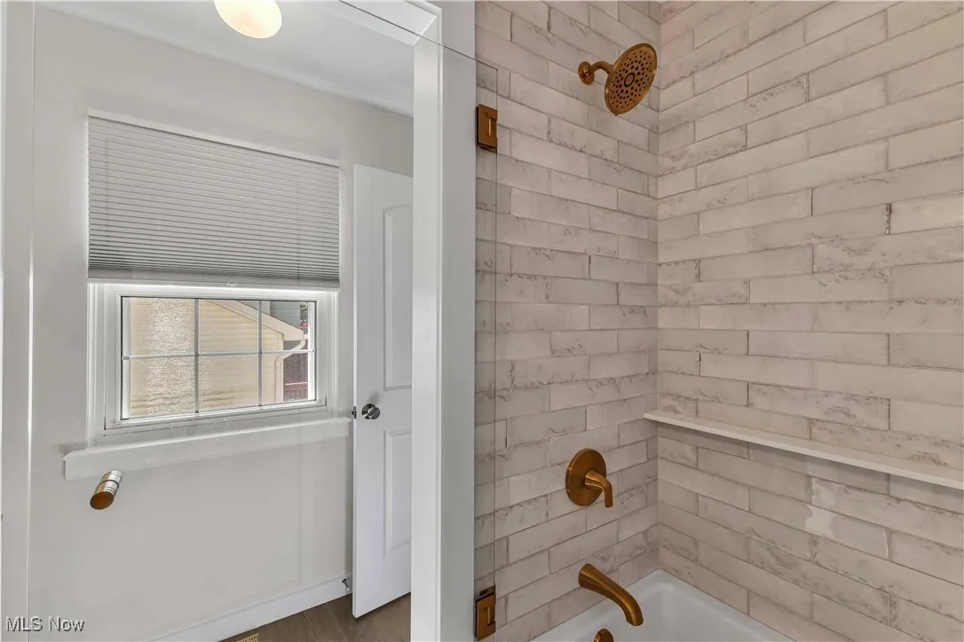 Remodeled full bathroom with a gorgeous tiled surround for the tub/shower. Modern hardware/faucets. Nice, neutral paint color. Updated flooring. Refinished the vanity with modern paint color, hardware, hard surface counter, new faucet and modern light fixture.