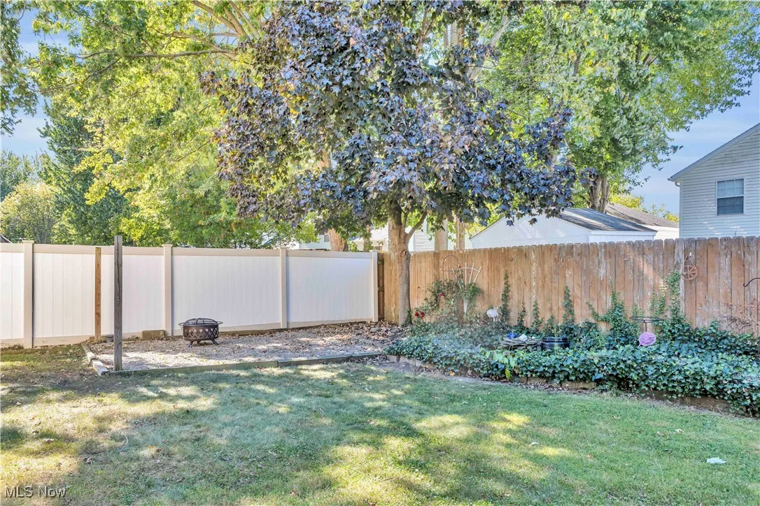 Backyard featuring gravel firepit area, fish pond and storage shed.
