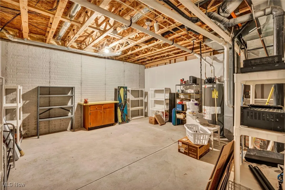 Unfinished below grade area featuring water heater