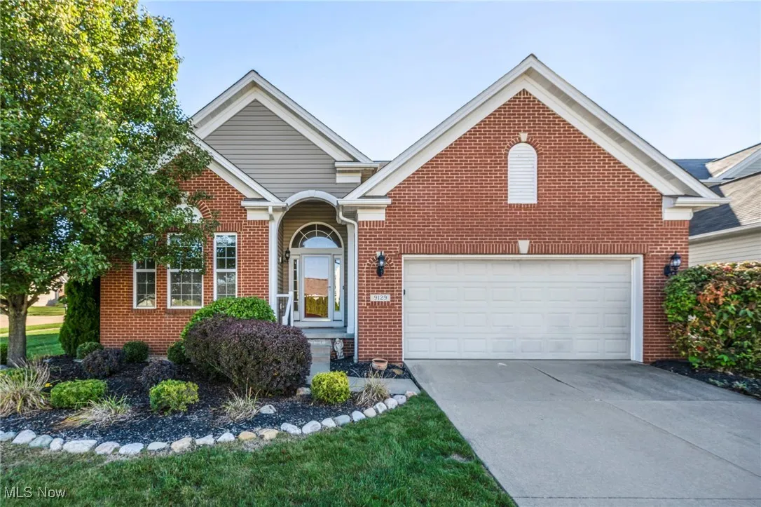 View of front of property with concrete driveway and brick siding