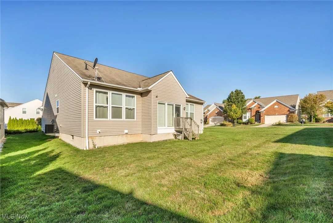 Back of house with a yard, crawl space, and a shingled roof
