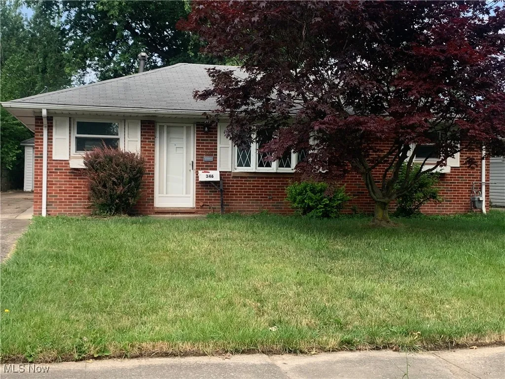 Bungalow featuring a front lawn, brick siding, and roof with shingles