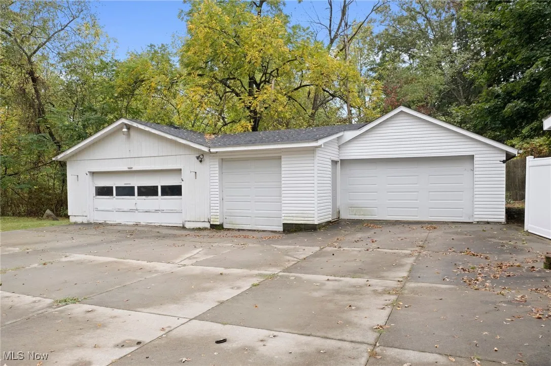 Detached garage featuring view of wooded area