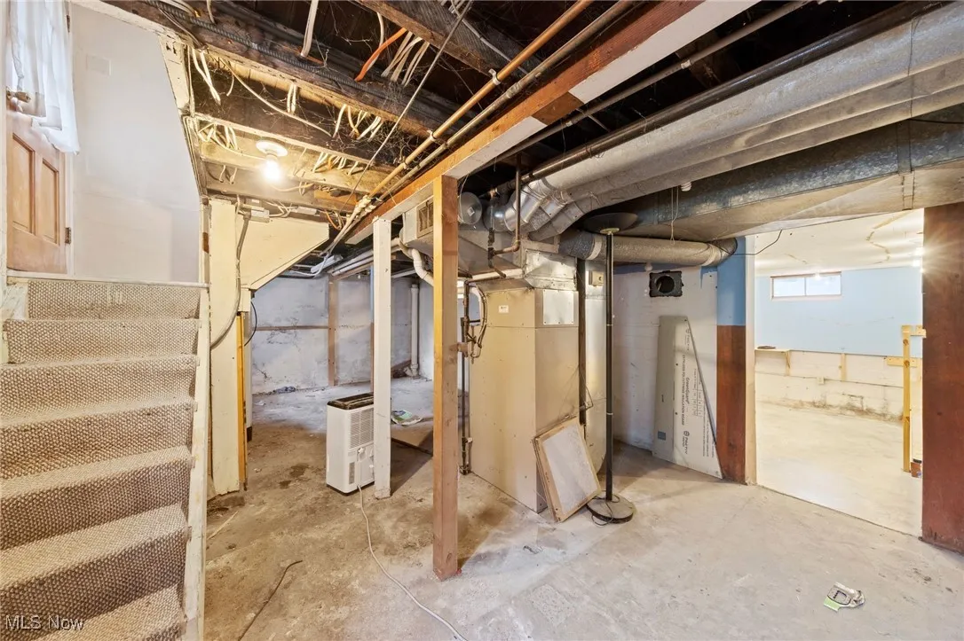 Below grade area featuring stairs and heating unit