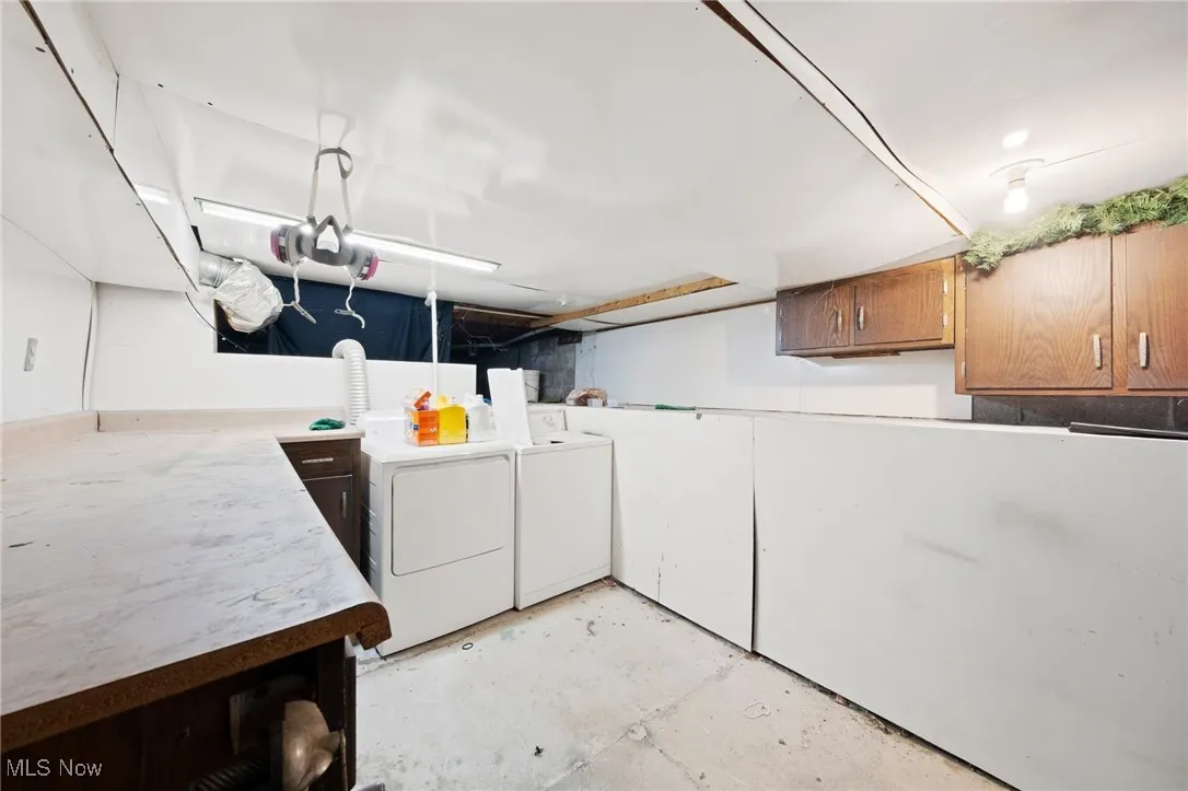 Washroom with cabinet space and washing machine and clothes dryer