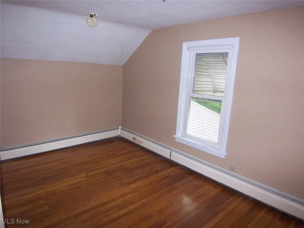 Bedroom #2 with dark wood finished floors, and lofted ceiling