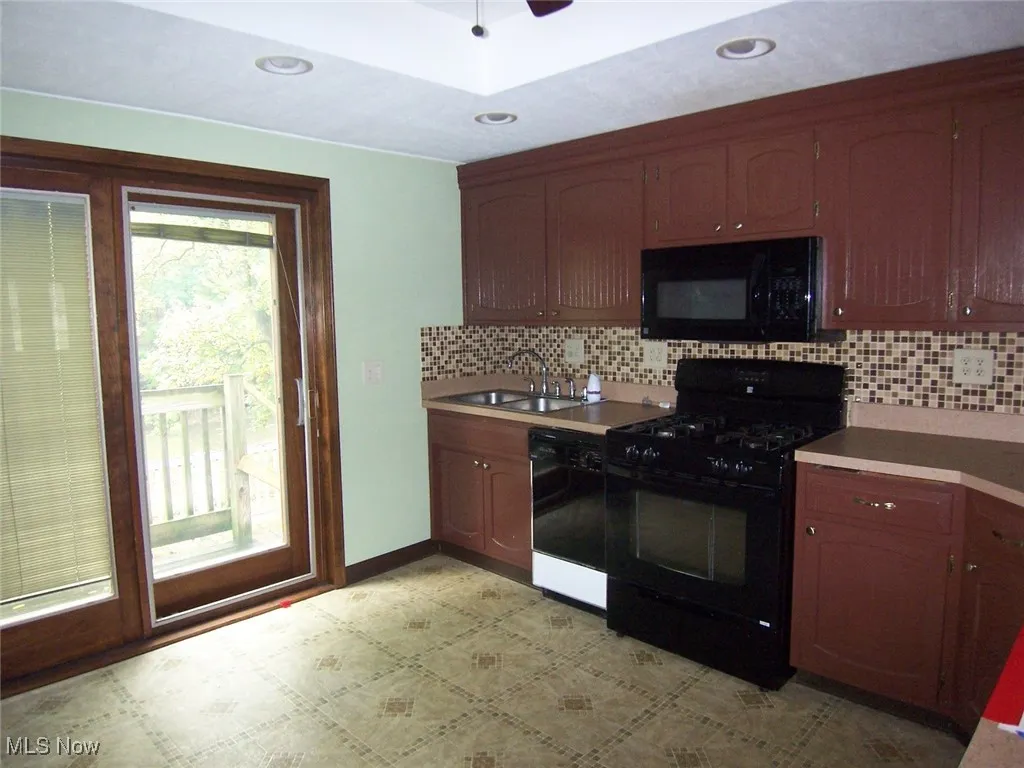 Kitchen featuring black appliances, tasteful backsplash, light countertops, recessed lighting, and ceiling fan, French doors to deck
