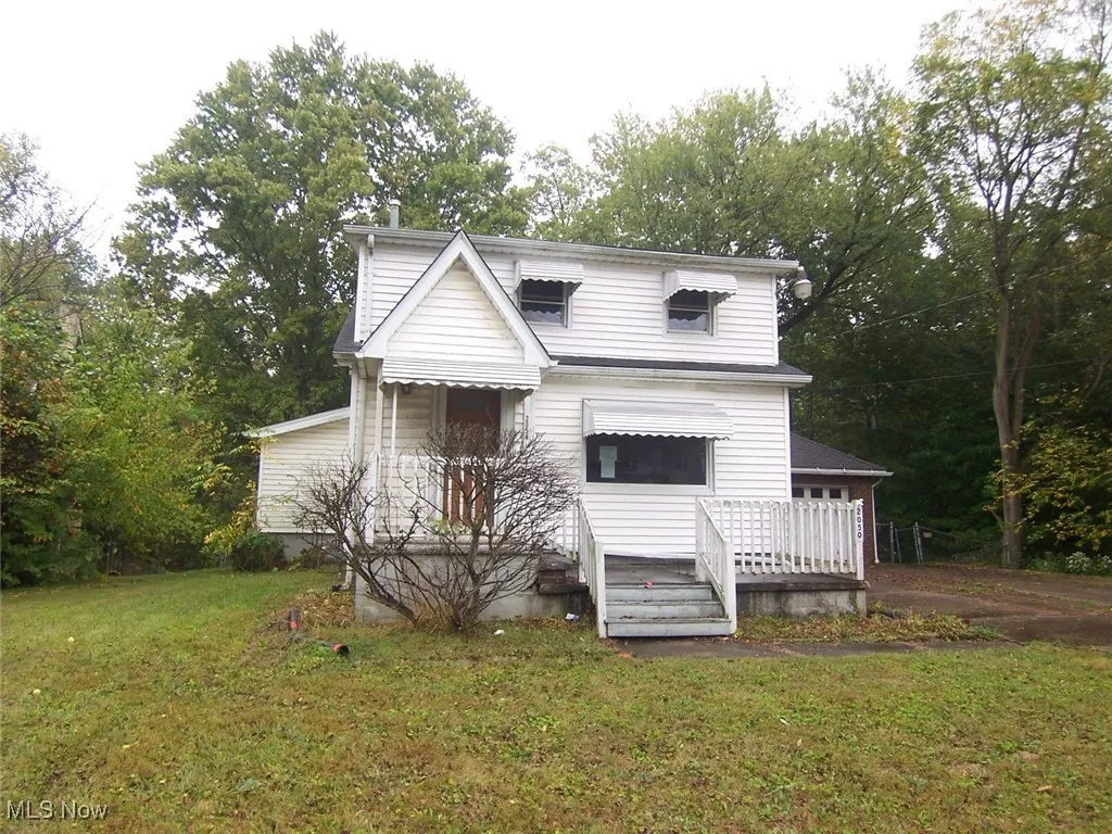 2 Story Home with a front lawn, a wooden deck, and view of wooded area