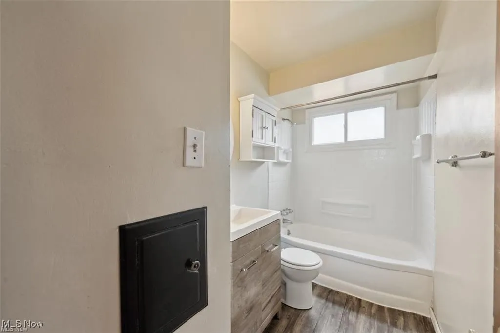 Main level Bathroom featuring vanity, bathtub / shower combination, and dark wood-style floors