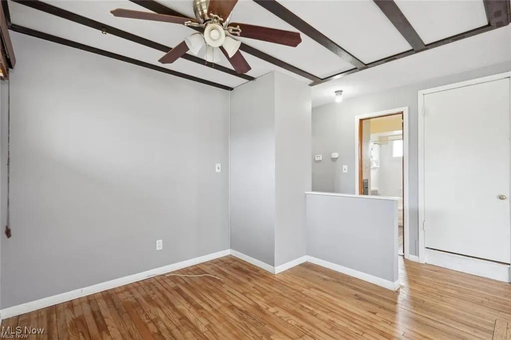 Empty room featuring hardwood / wood-style flooring and ceiling fan