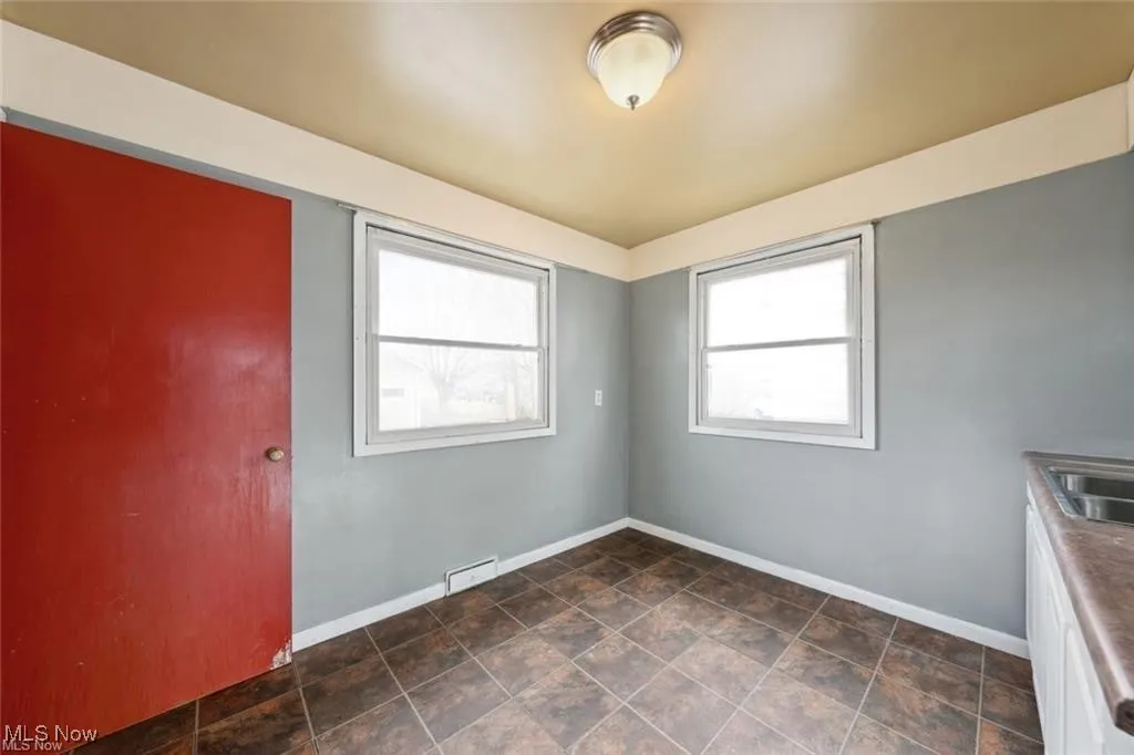 Spare room with baseboards and stone finish floors