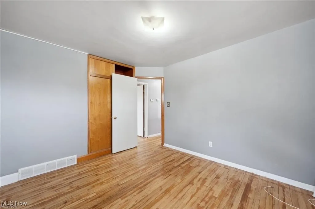Unfurnished bedroom featuring light wood-style floors and a closet