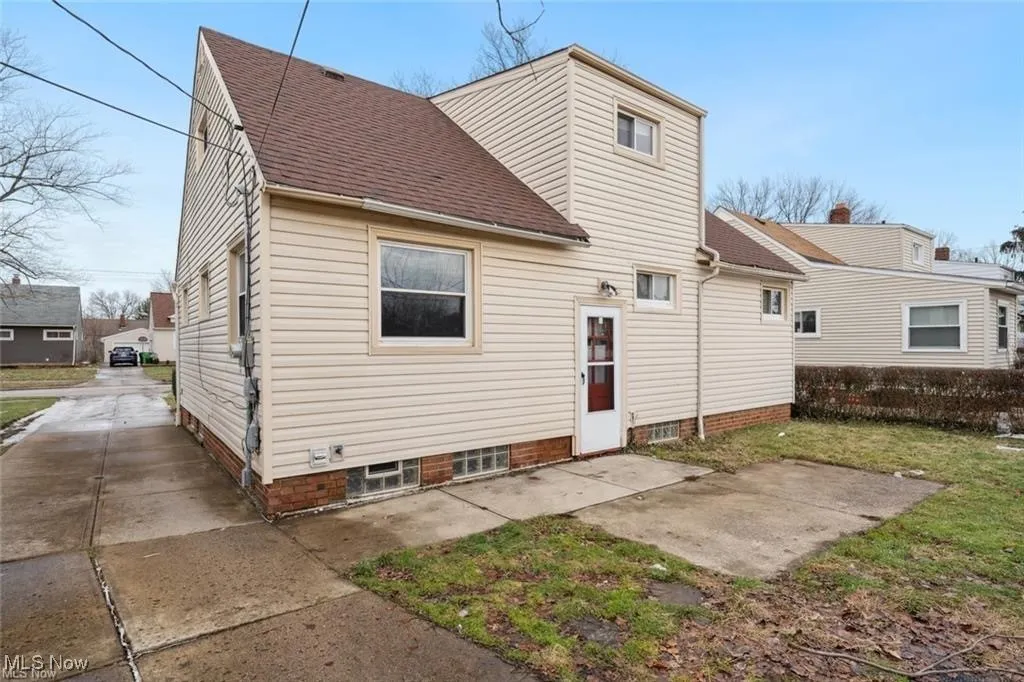 Back of house featuring a shingled roof and a patio