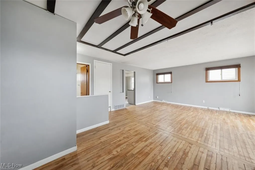 Empty room featuring light wood-type flooring and a ceiling fan