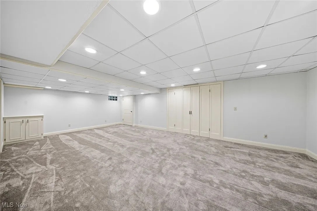 Finished below grade area featuring carpet floors, a drop ceiling, and recessed lighting