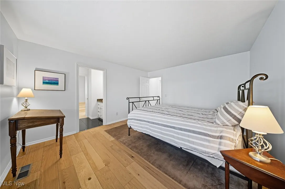 Bedroom with hardwood / wood-style flooring and baseboards