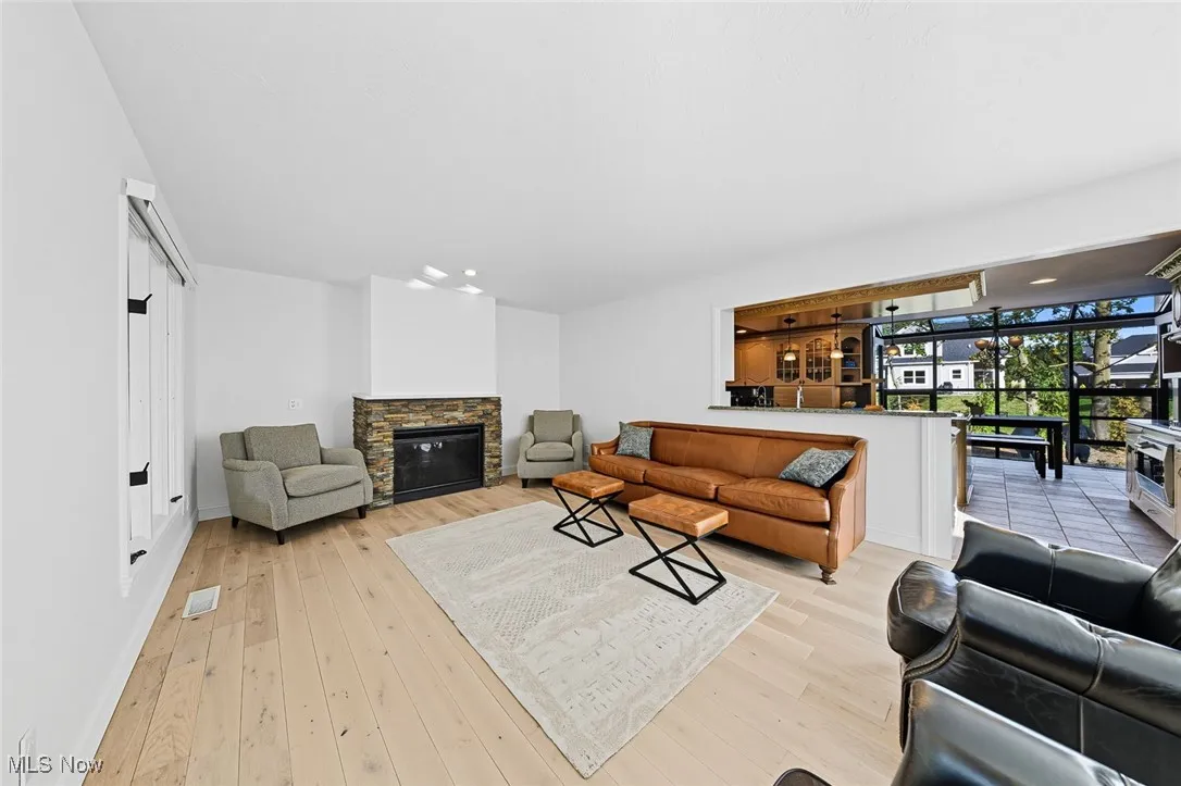 Living room with a fireplace and light wood-type flooring