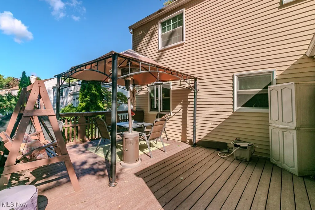 Wooden deck featuring a gazebo and outdoor dining space
