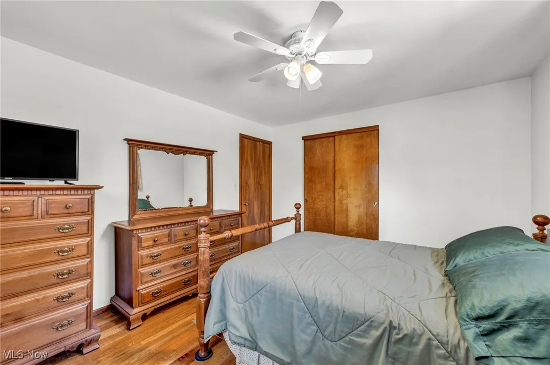 Bedroom featuring wood finished floors, a ceiling fan, and a closet