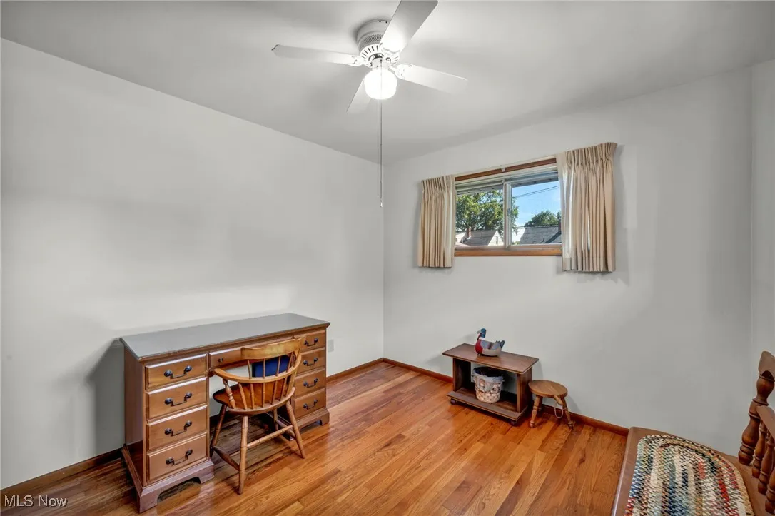 Home office with wood finished floors and ceiling fan