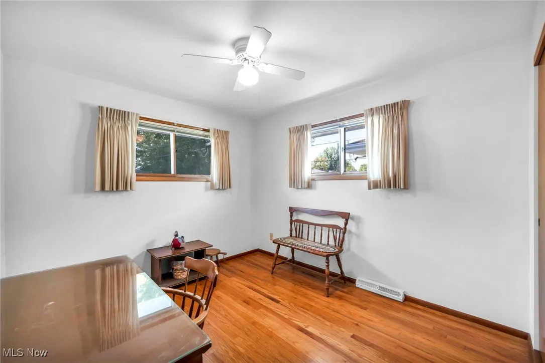 Living area with light wood finished floors and ceiling fan