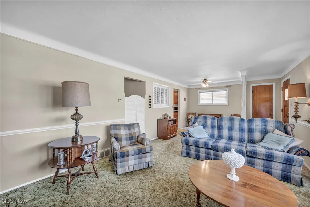 Living area with carpet floors and ceiling fan