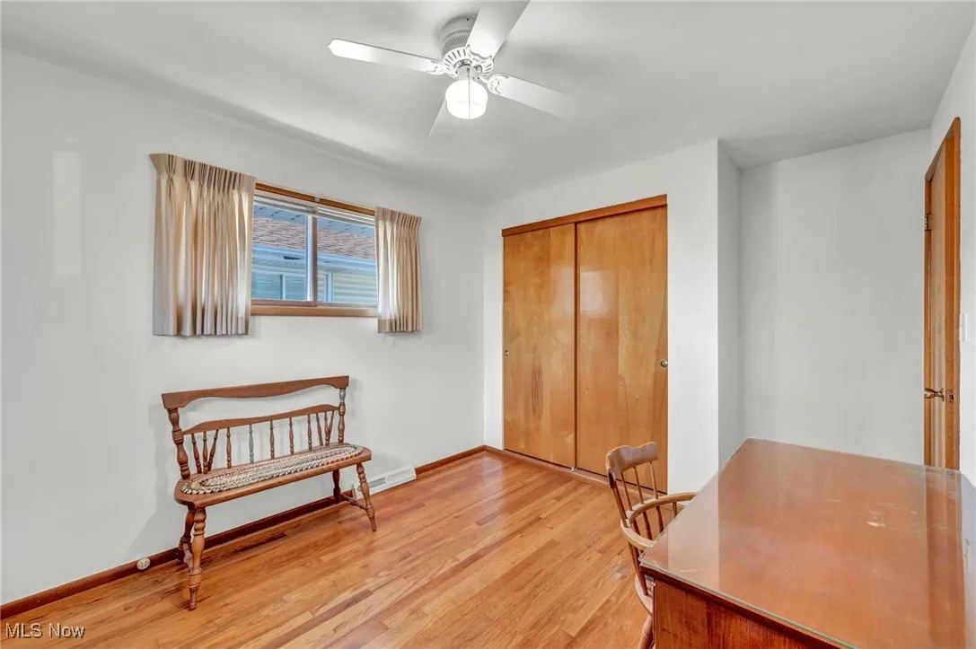 Home office featuring light wood-type flooring and a ceiling fan