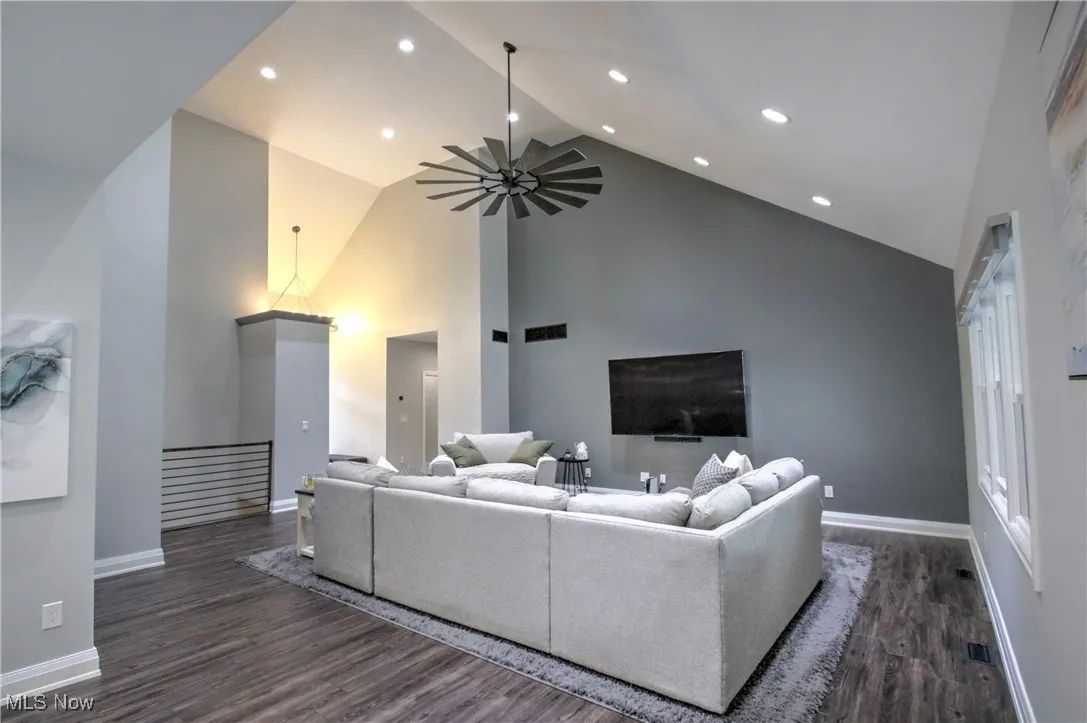 Living room featuring high vaulted ceiling, dark wood-style floors, ceiling fan, and recessed lighting