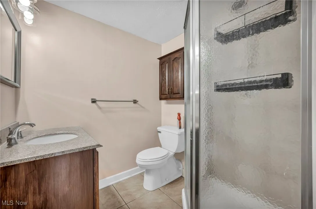 Bathroom featuring vanity, a stall shower, and light tile patterned floors
