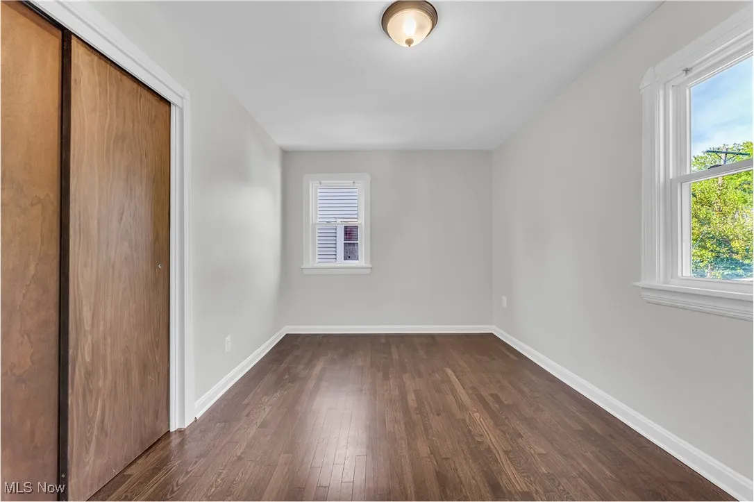 Unfurnished bedroom featuring dark wood finished floors and a closet
