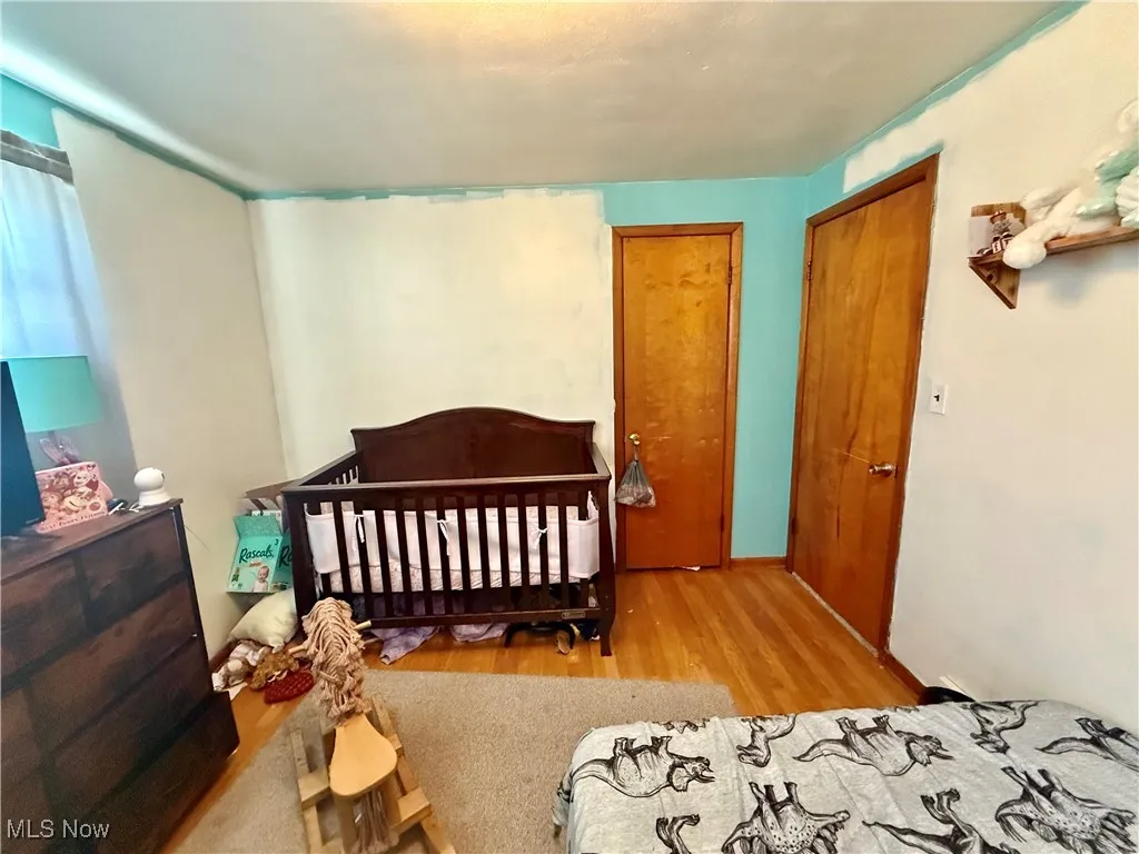 Bedroom featuring light wood-type flooring and a nursery area