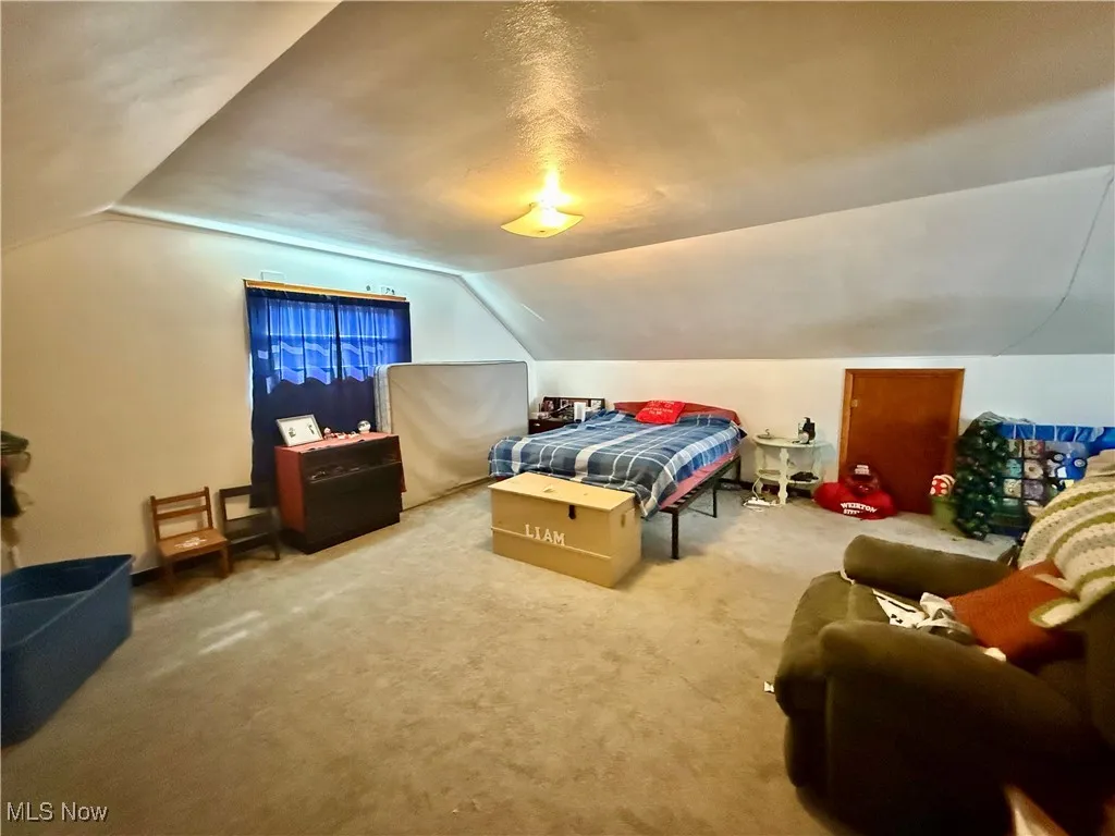 Carpeted bedroom featuring lofted ceiling