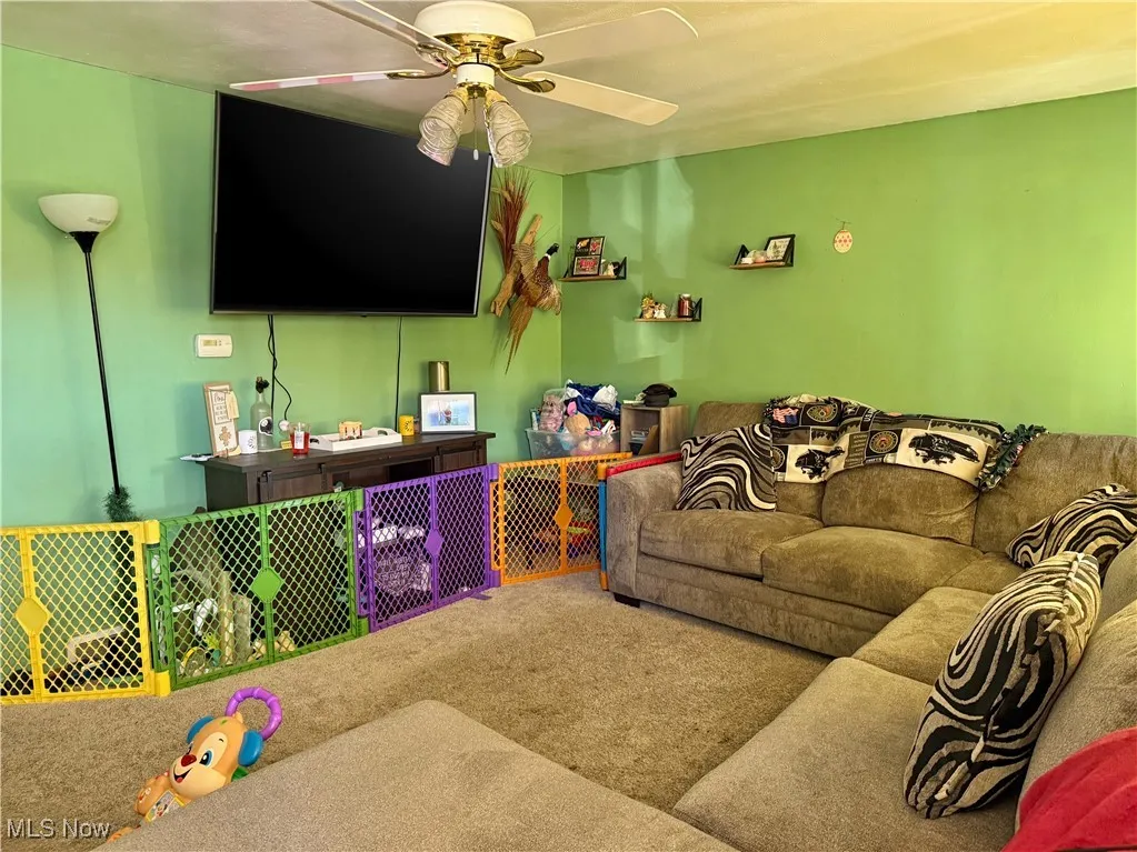 Living room with carpet flooring and a ceiling fan